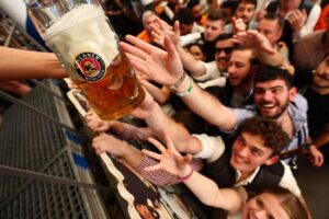 Visitantes de la "Oktoberfest" se afanan en conseguir una jarra este 20 de septiembre en Münich. EFE/EPA/ANNA SZILAGYI