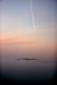 La niebla cubre este jueves la ría de Ares dejando ver solo la cima del monte Breamo, en una jornada de estabilidad meteorológica generalizada en España donde se prevén ascensos generalizados en las temperaturas, que contarán con máximas en la mitad sudoeste peninsular. EFE/Cabalar
