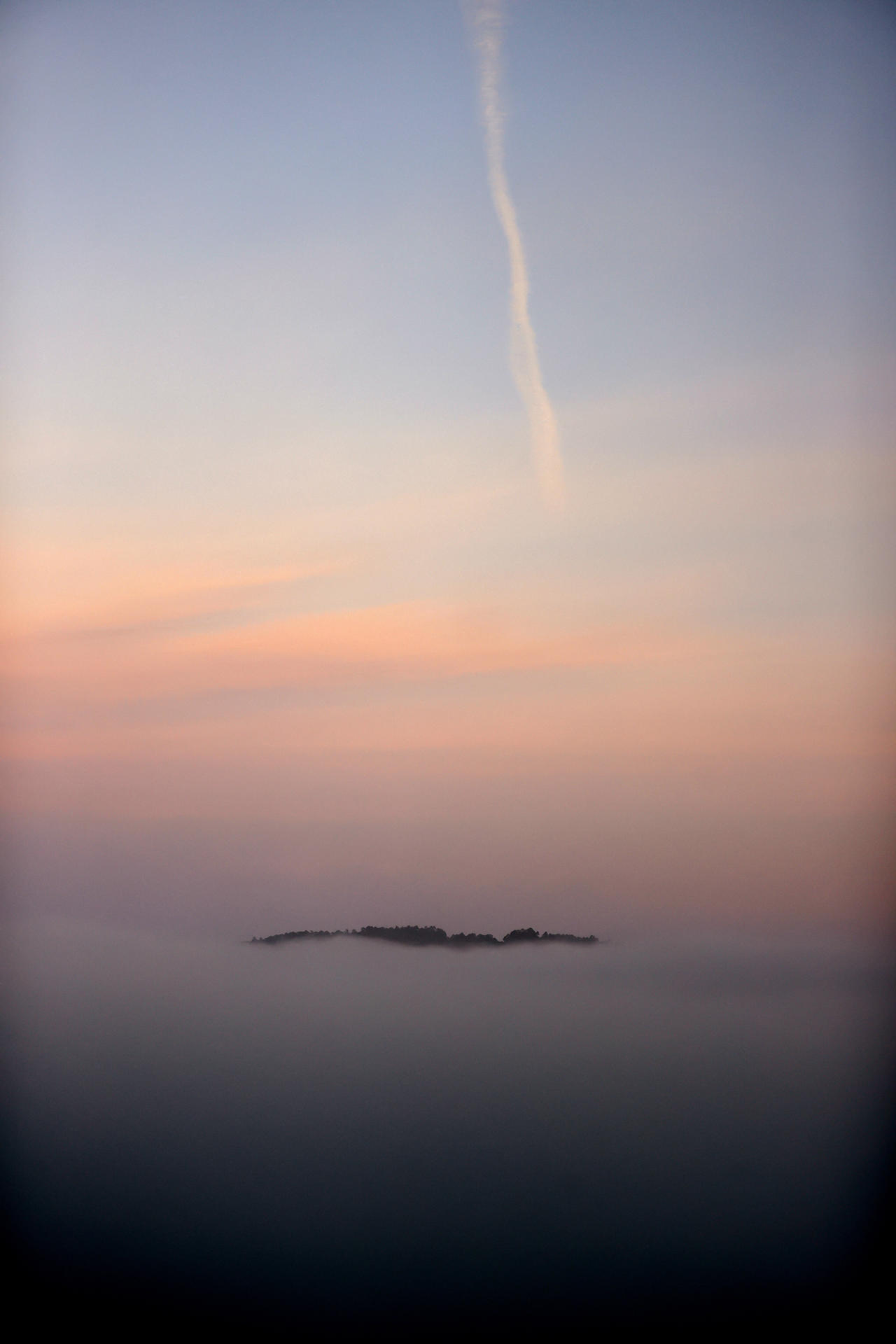 La niebla cubre este jueves la ría de Ares dejando ver solo la cima del monte Breamo, en una jornada de estabilidad meteorológica generalizada en España donde se prevén ascensos generalizados en las temperaturas, que contarán con máximas en la mitad sudoeste peninsular. EFE/Cabalar