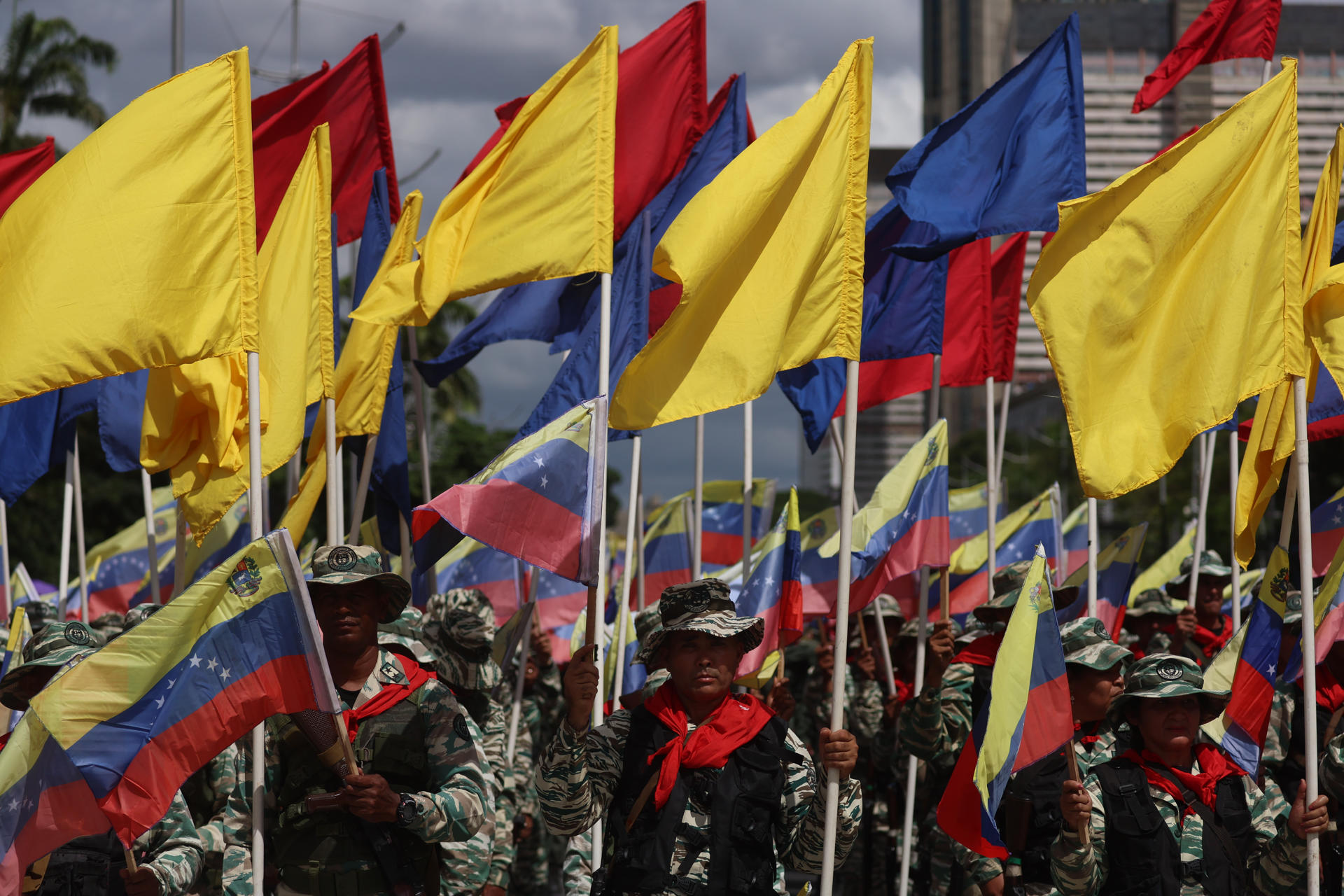 Personas sostienen banderas durante un ejercicio militar este martes, en Caracas (Venezuela).EFE/ Miguel Gutiérrez
