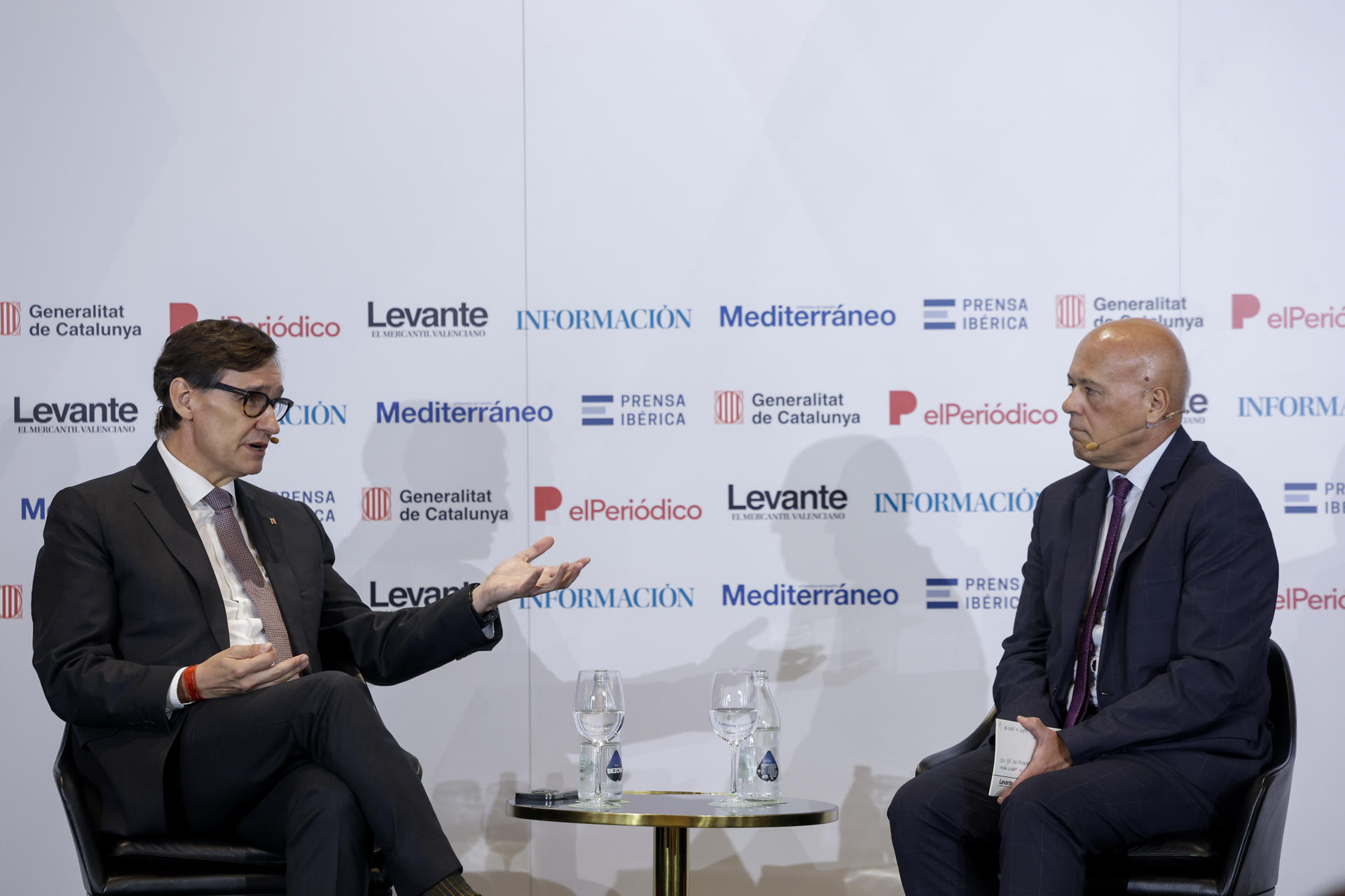 El presidente de la Generalitat catalana, Salvador Illa, junto al director de Levante-EMV, Joan-Carles Martí (d), durante su intervención en el encuentro informativo organizado por el diario Levante EMV y El Periódico de Catalunya. EFE/Biel Aliño