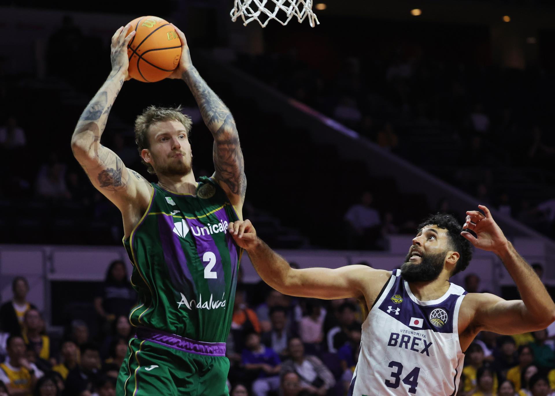 Aleksander Balcerowski (i) del Unicaja y Grant Jerrett del Utsunomiya Brex. EFE/EPA/HOW HWEE YOUNG