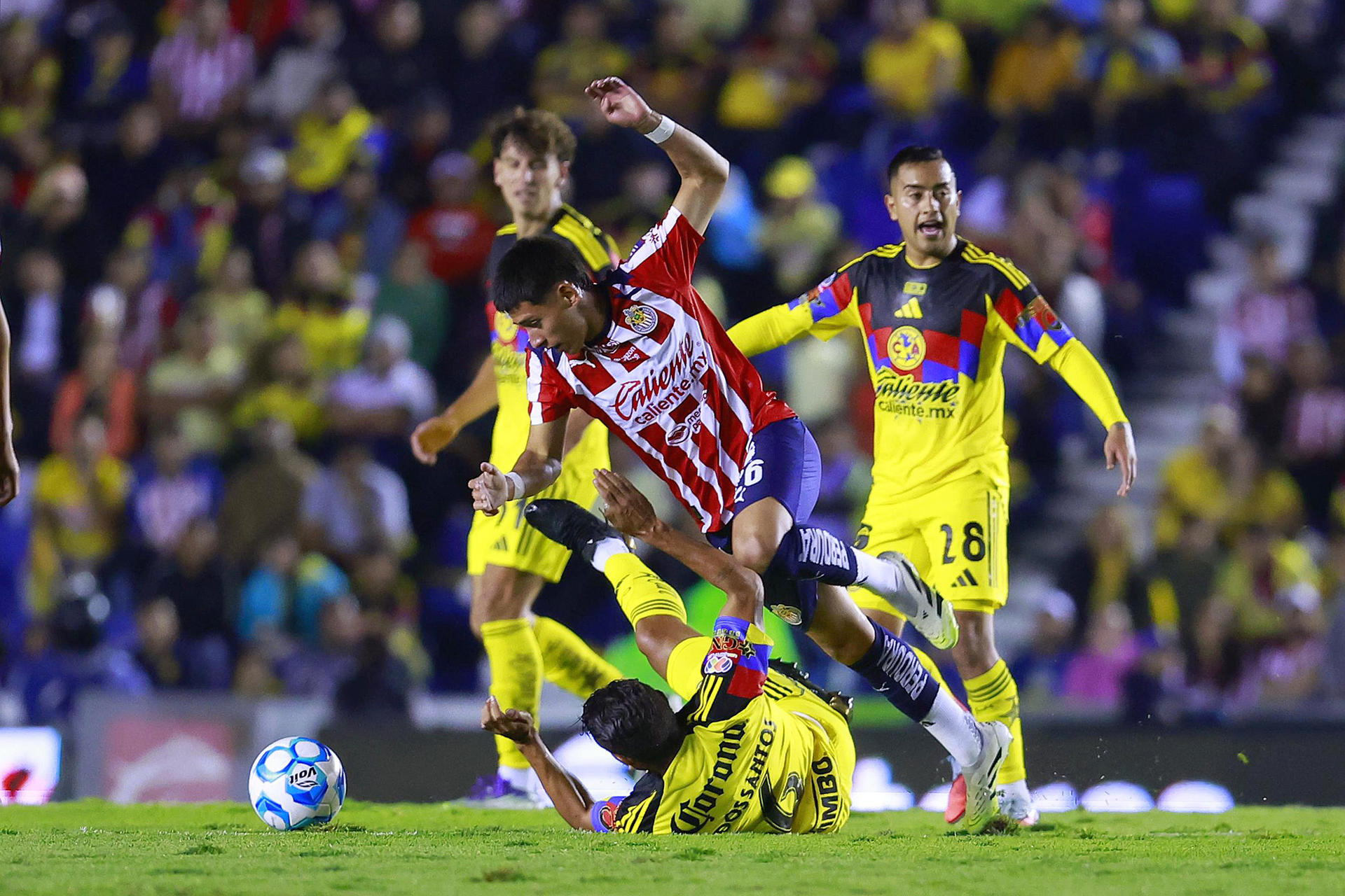 Jonathan dos Santos (abajo) del América disputa la posesión del balón con Santiago Sandoval (arriba) del Guadalajara durante un partido del torneo Apertura 2025 de la Liga MX en Ciudad de México (México). EFE/ Sáshenka Gutiérrez