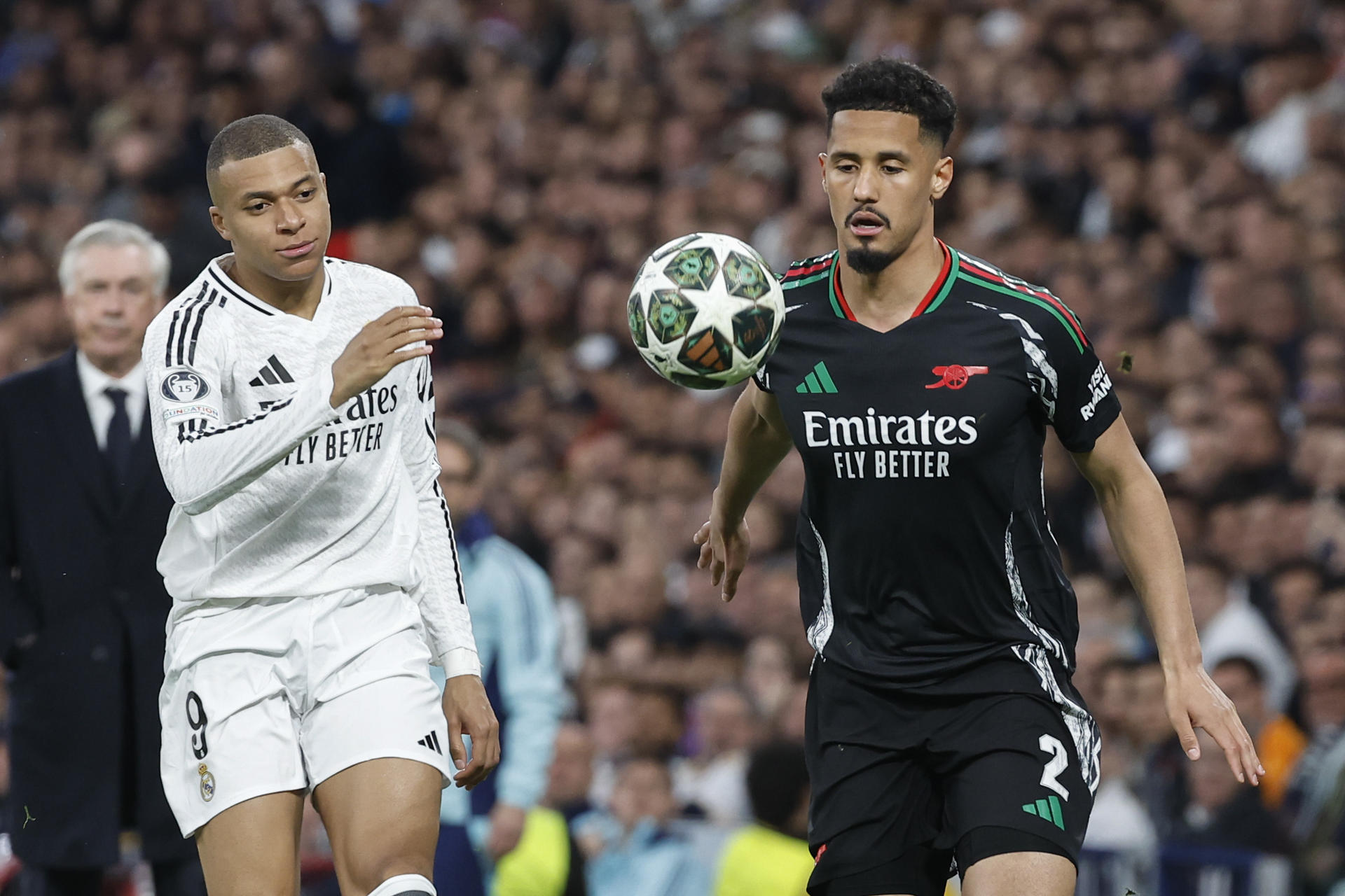 El defensa del Arsenal William Saliba pugna por el balón con el delantero del Real Madrid Kylian Mbappé, durante el partido de vuelta de cuartos de final de la pasada edición de la Liga de Campeones. EFE/Chema Moya