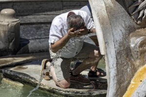 Un hombre se refresca en la Fuente de la Barcaza el pasado mes de junio, en una fotografía de archivo. EFE/ Massimo Percossi