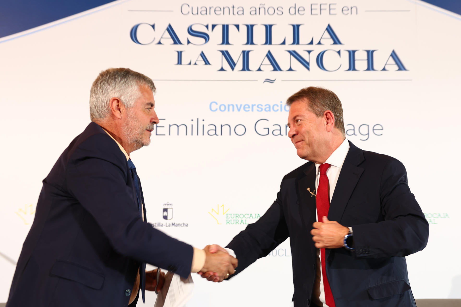 El presidente de EFE, Miguel Ángel Oliver (i), estrecha la mano del presidente de Castilla-La Mancha, Emiliano García-Page, durante el encuentro informativo que mantuvieron con motivo de la celebración del 40 aniversario de la Agencia en Castilla-La Mancha, este viernes en Toledo. EFE/ Ismael Herrero
