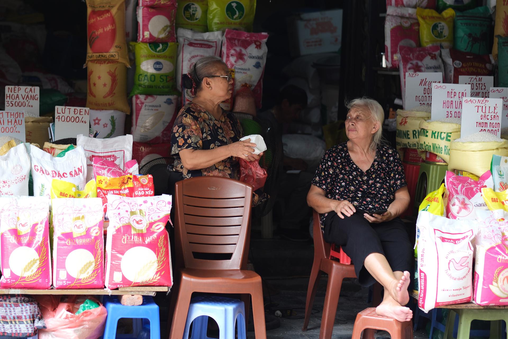 HANÓI (Vietnam), 15/09/2025.- Mujeres que venden arroz hablan en sus puestos en una calle de Hanói. Vietnam. EFE/EPA/LUONG THAI LINH