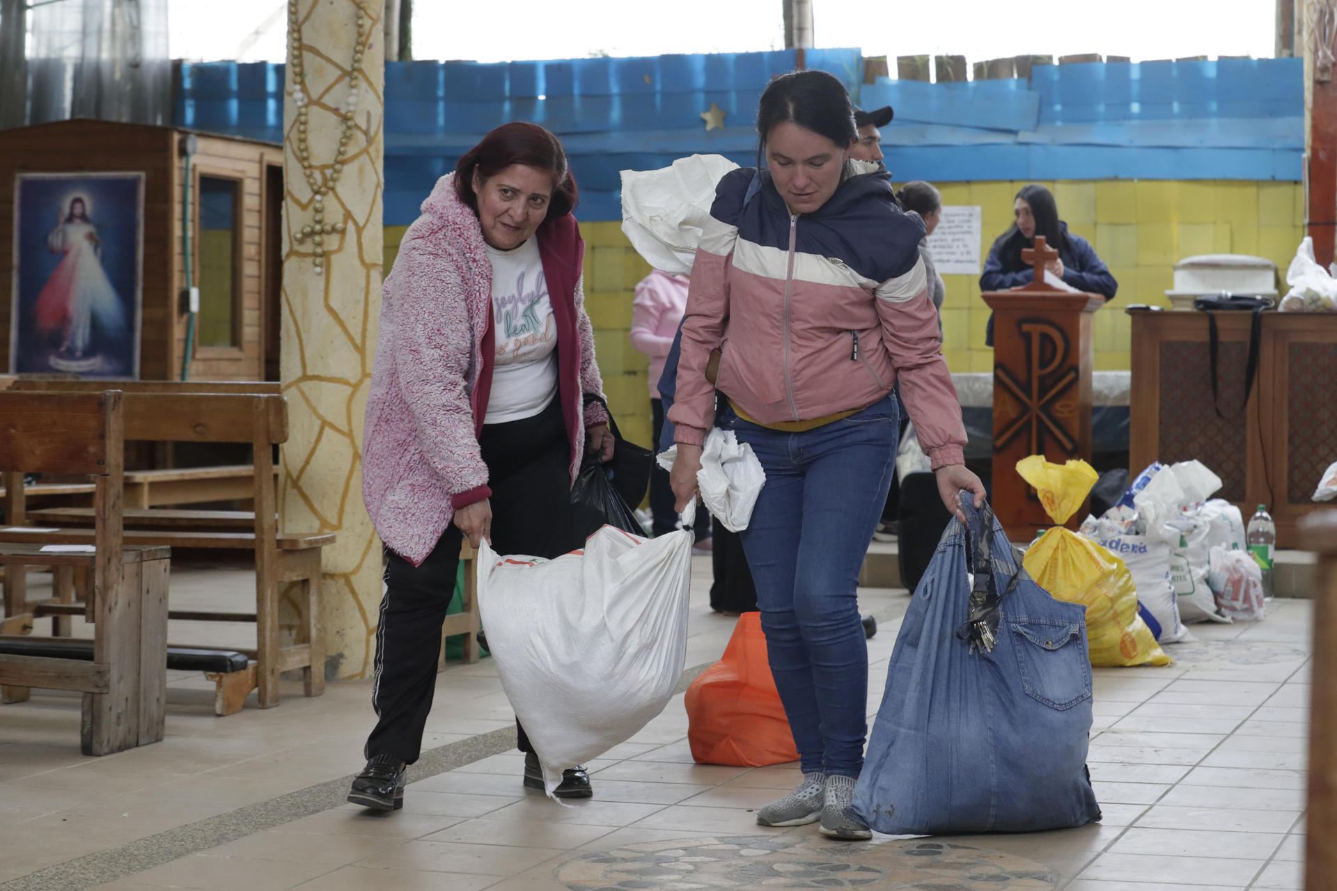 Fotografía del 2 de septiembre de 2025 que muestra a personas recibiendo paquetes con alimentos y utensilios de aseo en Zipaquirá (Colombia). EFE/ Carlos Ortega
