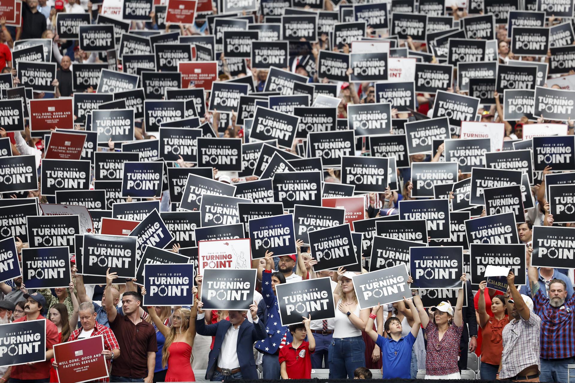 Los asistentes sostienen carteles durante el servicio memorial público del activista político Charlie Kirk en el State Farm Stadium en Glendale, Arizona, EE. UU. EFE/CAROLINE BREHMAN