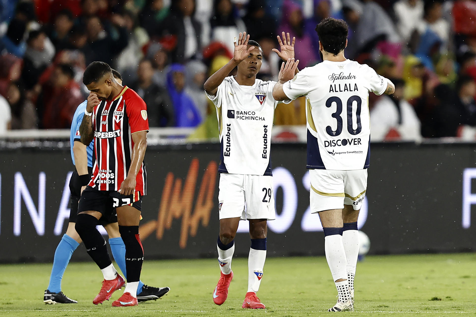 Bryan Ramírez (c) y Gian Franco Allala (d) de la Liga de Quito reaccionan este jueves al finalizar el partido por los cuartos de final de la Copa Libertadores frente al Sao Paulo en el estadio Rodrigo Paz Delgado. EFE/ José Jácome