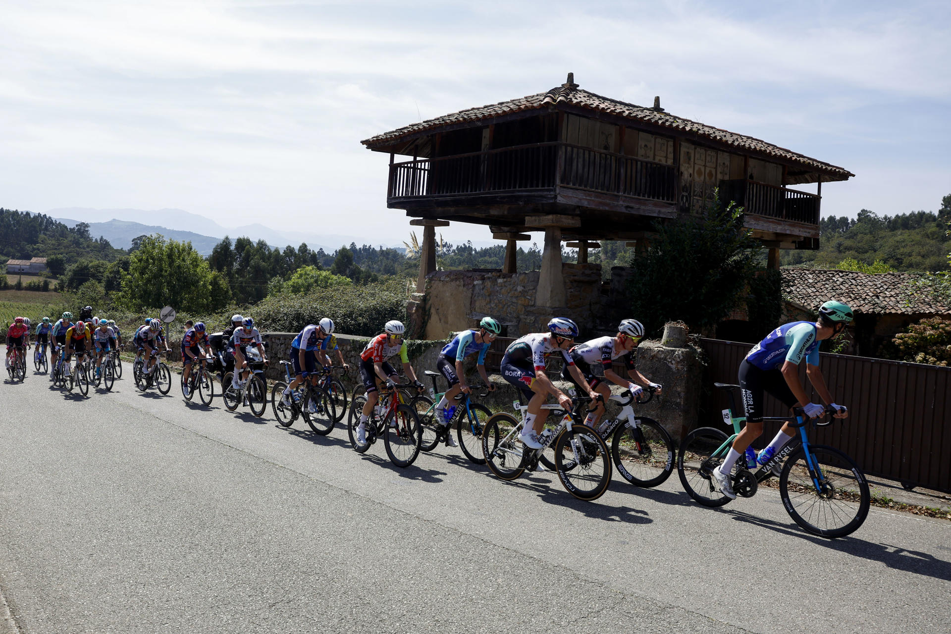El pelotón durante la decimocuarta etapa de la Vuelta ciclista a España que se disputa sobre 135,9 kilómetros en Asturias con comienzo en Avilés y final en las duras rampas del Alto de la Ferrapona, en los lagos de Somiedo. EFE/ Juan González