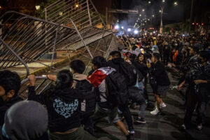 Decenas de jóvenes fueron captados este domingo, 28 de septiembre, al derrumbar una línea de vallas metálicas de protección, durante un protesta antigubernamental, en Lima (Perú). EFE/John Reyes