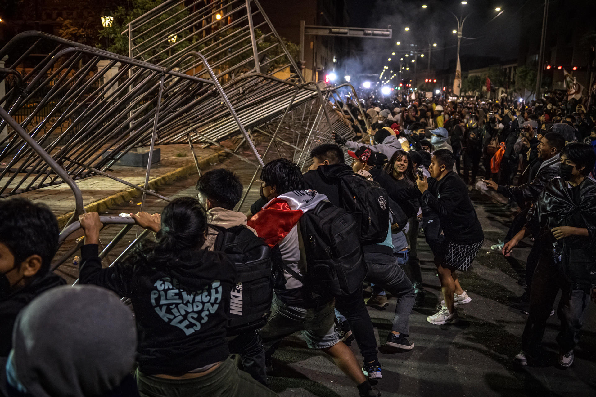 Decenas de jóvenes fueron captados este domingo, 28 de septiembre, al derrumbar una línea de vallas metálicas de protección, durante un protesta antigubernamental, en Lima (Perú). EFE/John Reyes