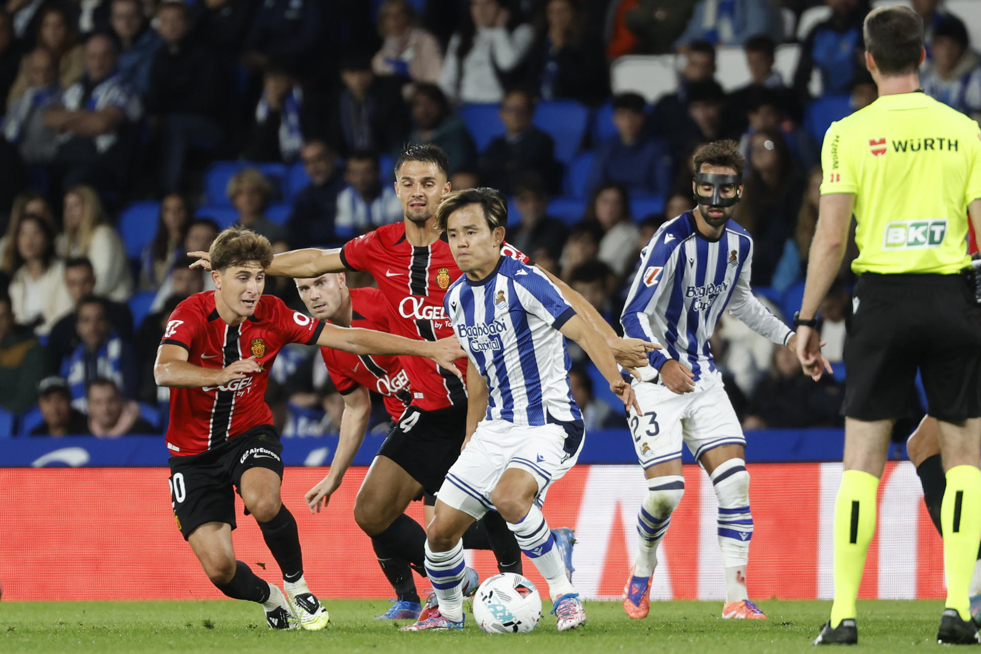 El delantero japonés de la Real Sociedad, Take Kubo (d), controla el balón ante el centrocampista del Mallorca, Pablo Torre, durante el encuentro correspondiente a la sexta jornada de LaLiga de fútbol que Real Sociedad y RCD Mallorca disputan en el Reale Arena, en San Sebastián. EFE/Juan Herrero
