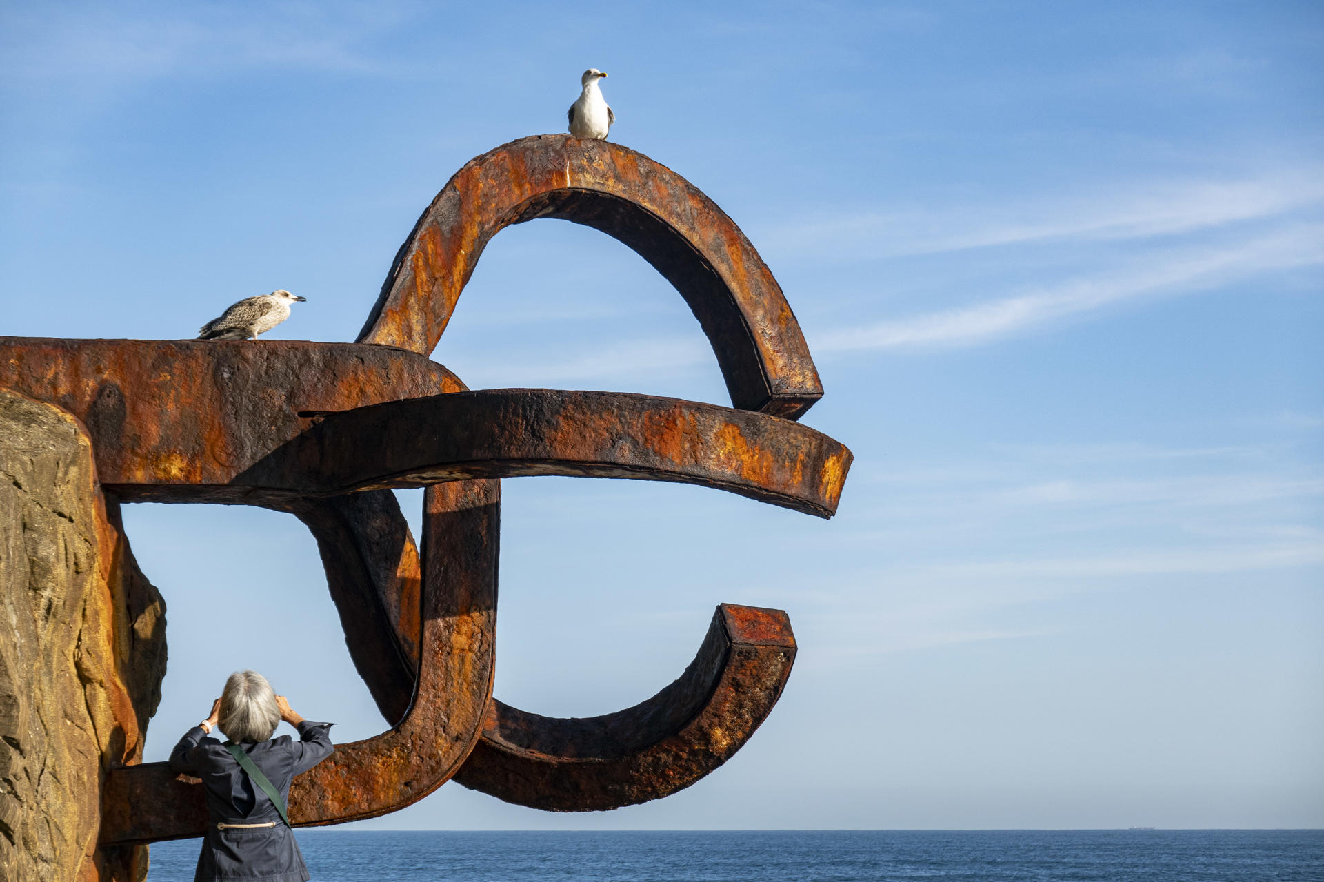 Una mujer fotografía la escultura El Peine del Viento, de Eduardo Chillida, este miércoles en San Sebastián.EFE/Javier Etxezarreta
