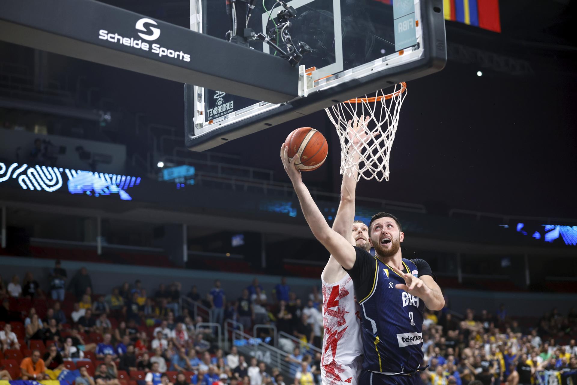 Michal Sokolowski (i) de Polonia y Jusuf Nurkic de Bosnia y Herzegovina en acción durante el partido de baloncesto del EuroBasket 2025 disputado en Riga, Letonia. EFE/EPA/TOMS KALNINS