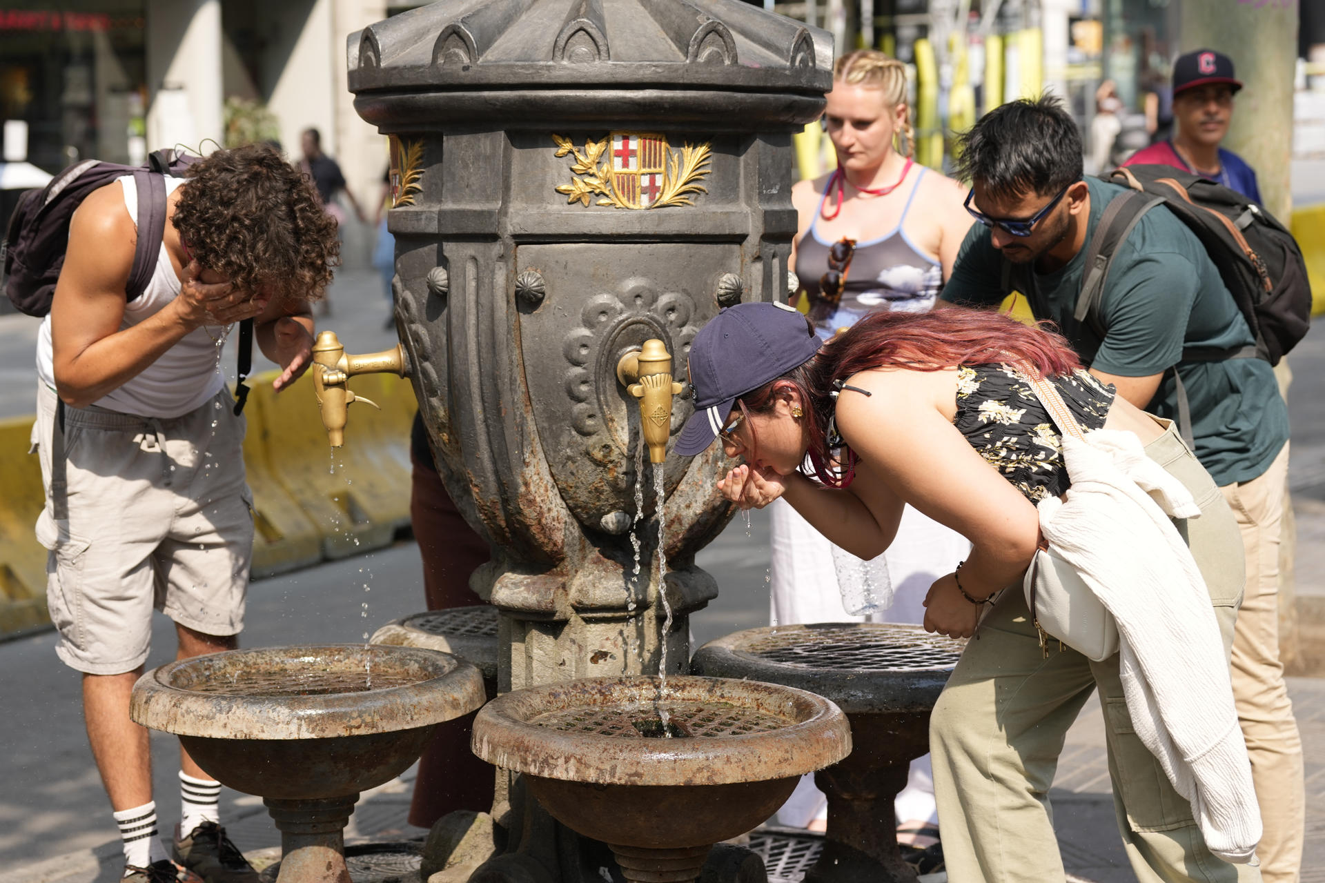Turistas refrescándose en agosto en la fuente de Canaletas, en Barcelona. EFE/Alejandro García
