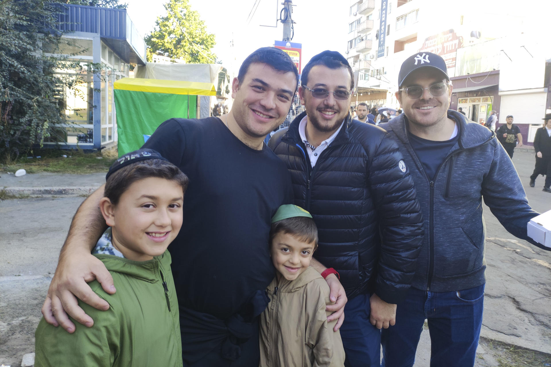 Benjamín Srugo abraza a sus dos hijos junto a su hermano Daniel (centro) y otro peregrino judío mexicano antes de participar en un rezo en la sinagoga construida en torno a la tumba de Rabí Najman de Bréslev en Ucrania con miles de correligionarios de todo el mundo para recibir el año nuevo judío. EFE/ Marcel Gascón