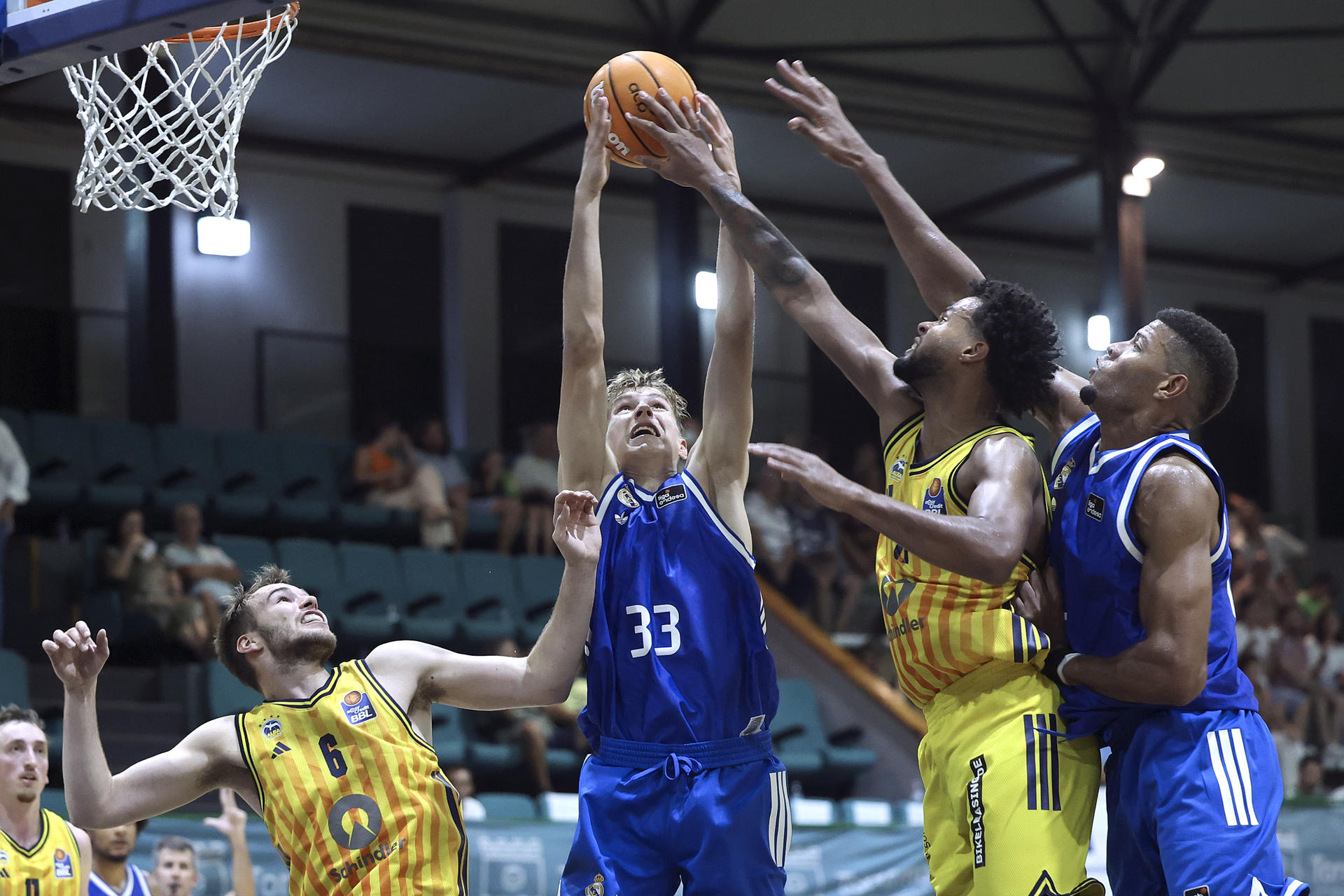 Los jugadores del Real Madrid Gunars Grinvalds (2i), y Walter Tavares (d) luchan por el balón con los jugagdores del Alba Berlón, Malte Delow (i) y Norris Agbakoko (2d), durante el encuentro entre Real Madrid y Alba Berlín del XIV Torneo Costa del Sol que se disputa en el pabellón San Miguel de la localidad de Torremolinos. EFE/Daniel Pérez