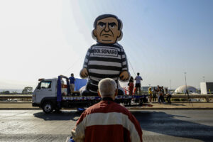 Una persona observa un muñeco alusivo al expresidente de Brasil Jair Bolsonaro durante un desfile este 12 de septiembre de 2025, en Brasilia (Brasil). EFE/ Antonio Lacerda