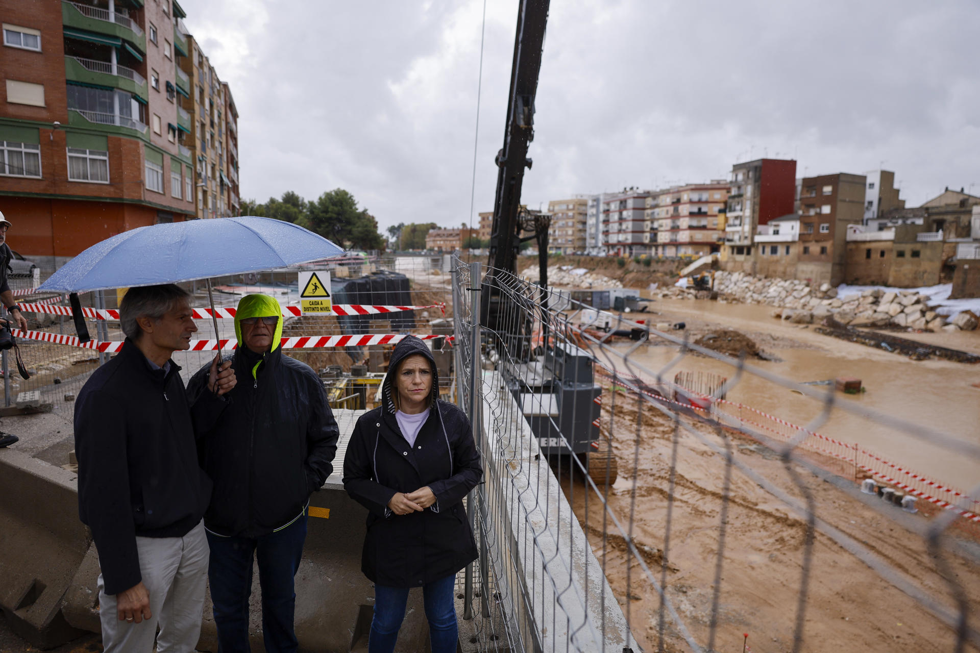 La delegada del Gobierno en la Comunitat Valenciana, Pilar Bernabé (d), junto al alcalde de Paiporta, Vicent Císcar (c), y al jefe de la Demarcación de Carreteras, Guillermo Llopis (i), junto al barranco del Poyo en Paiporta este martes. EFE/ Kai Forsterling
