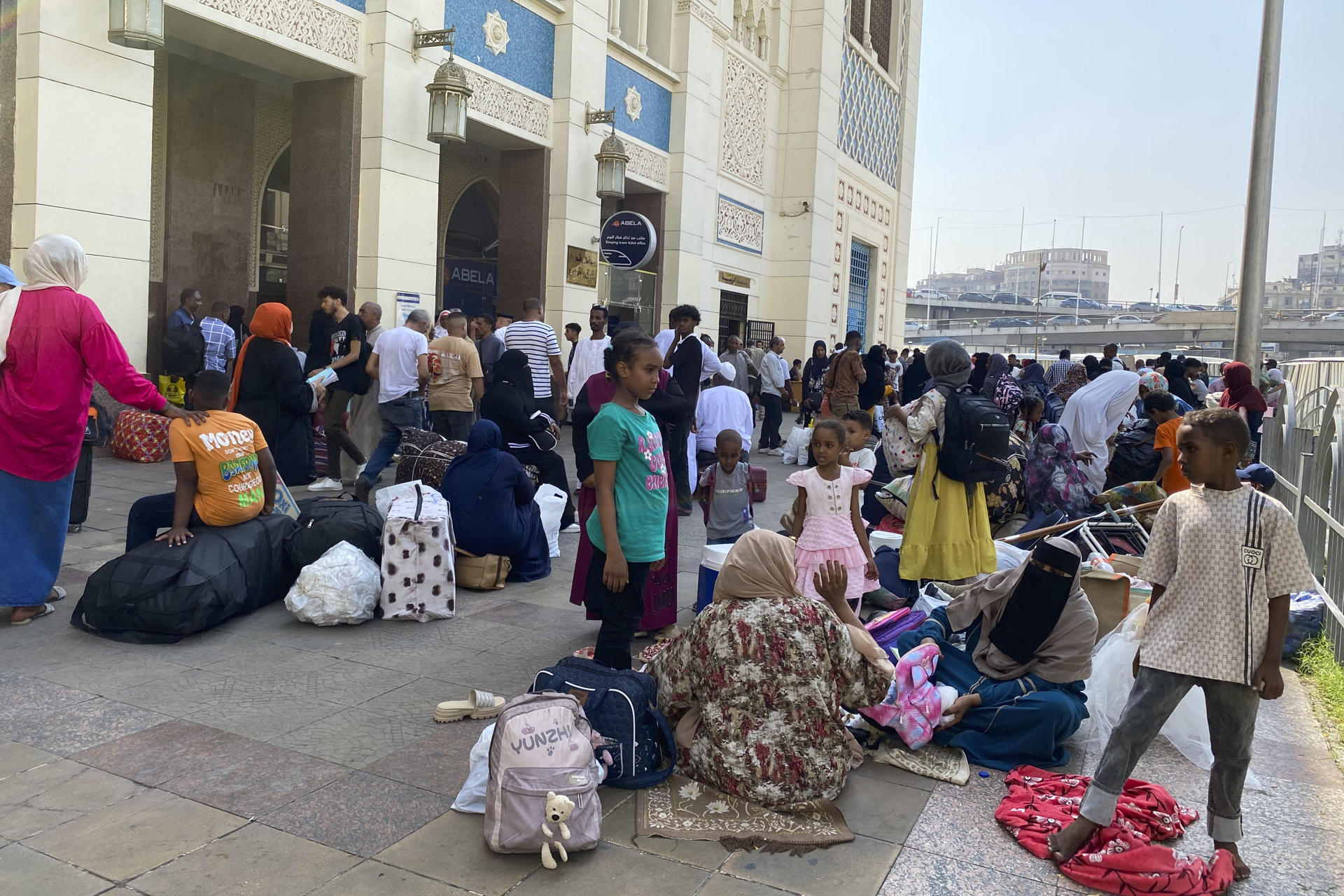 Decenas de familias de refugiados sudaneses descansan sobre su equipaje antes de entrar a la estación de Ramsés, donde cogerán un tren para regresar a Sudán. En la céntrica estación de ferrocarril de Ramsés, en El Cairo, el bullicio habitual se mezcla con aires de despedida y esperanza. Alrededor de 940 refugiados sudaneses, cargados con grandes bultos y maletas con pertenencias y recuerdos acumulados durante su exilio, se preparan para abordar el tren que les llevará de regreso a su país. EFE/Rosa Soto