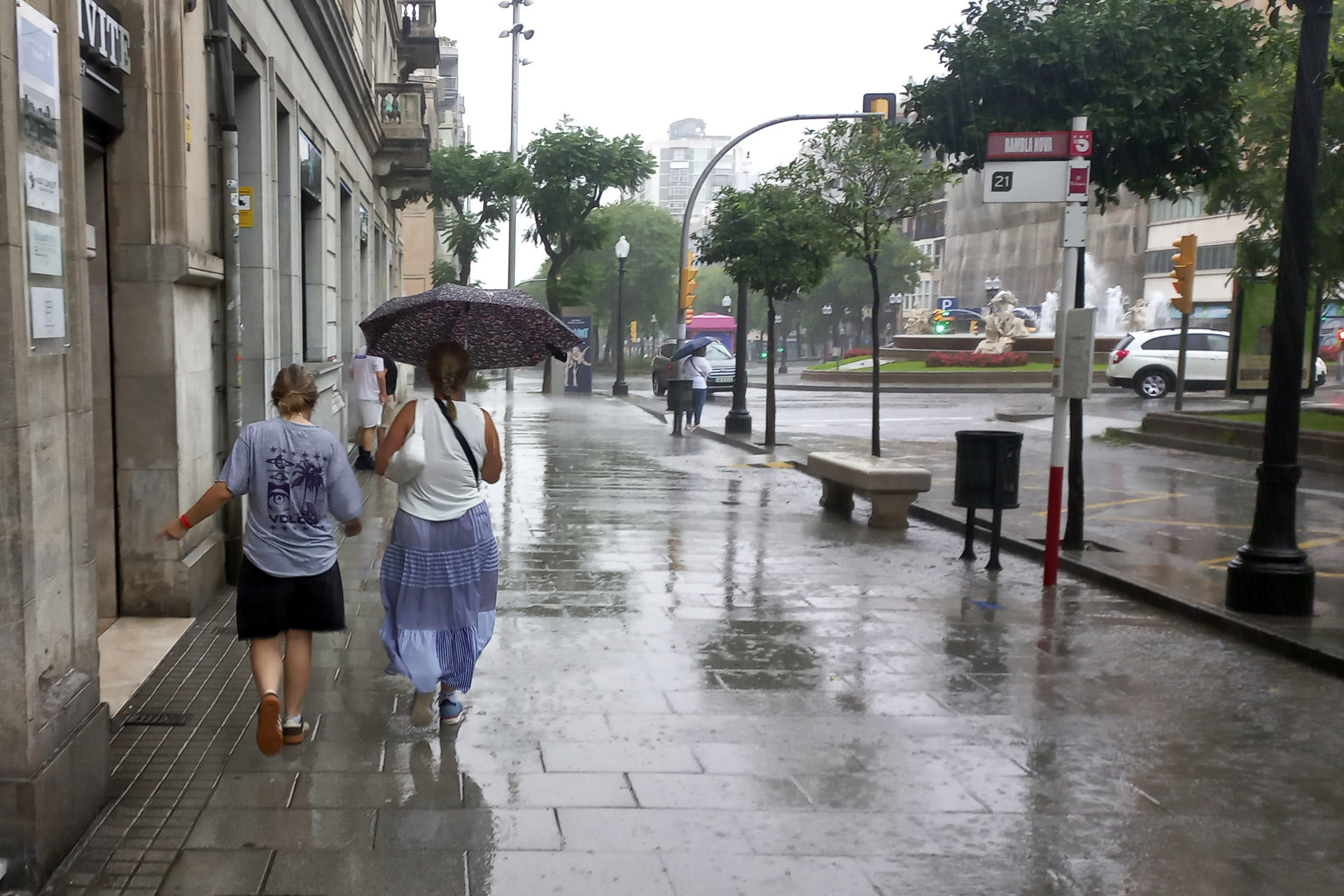 Imagen de dos personas protegiéndose de la lluvia en el centro de Tarragona, en julio pasado. EFE/Javier Díaz