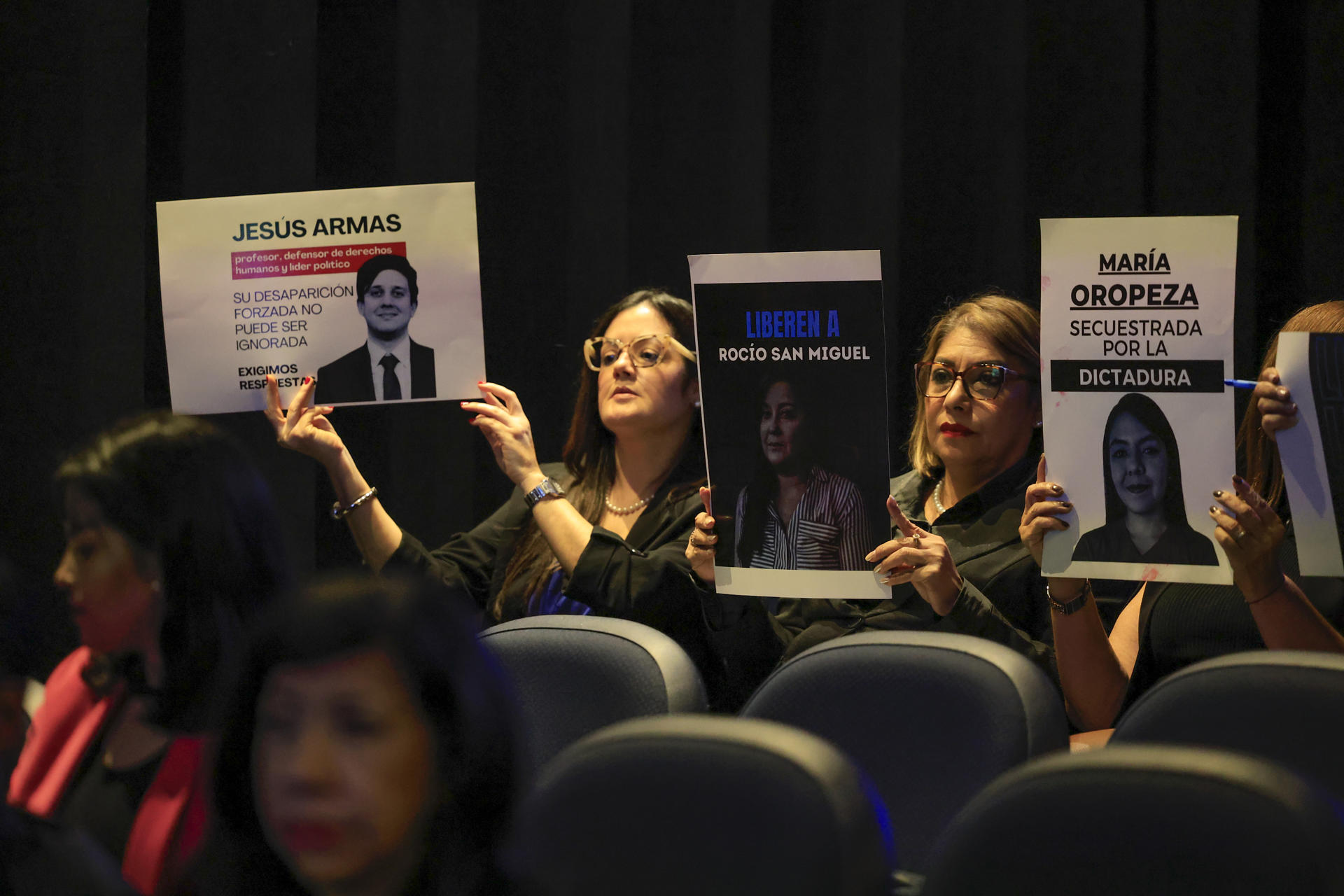 Personas sostienen carteles con la imagen de ciudadanos detenidos, este martes durante el conversatorio 'Venezuela Memoria y Justicia', en ciudad de Panamá (Panamá). EFE/ Bienvenido Velasco