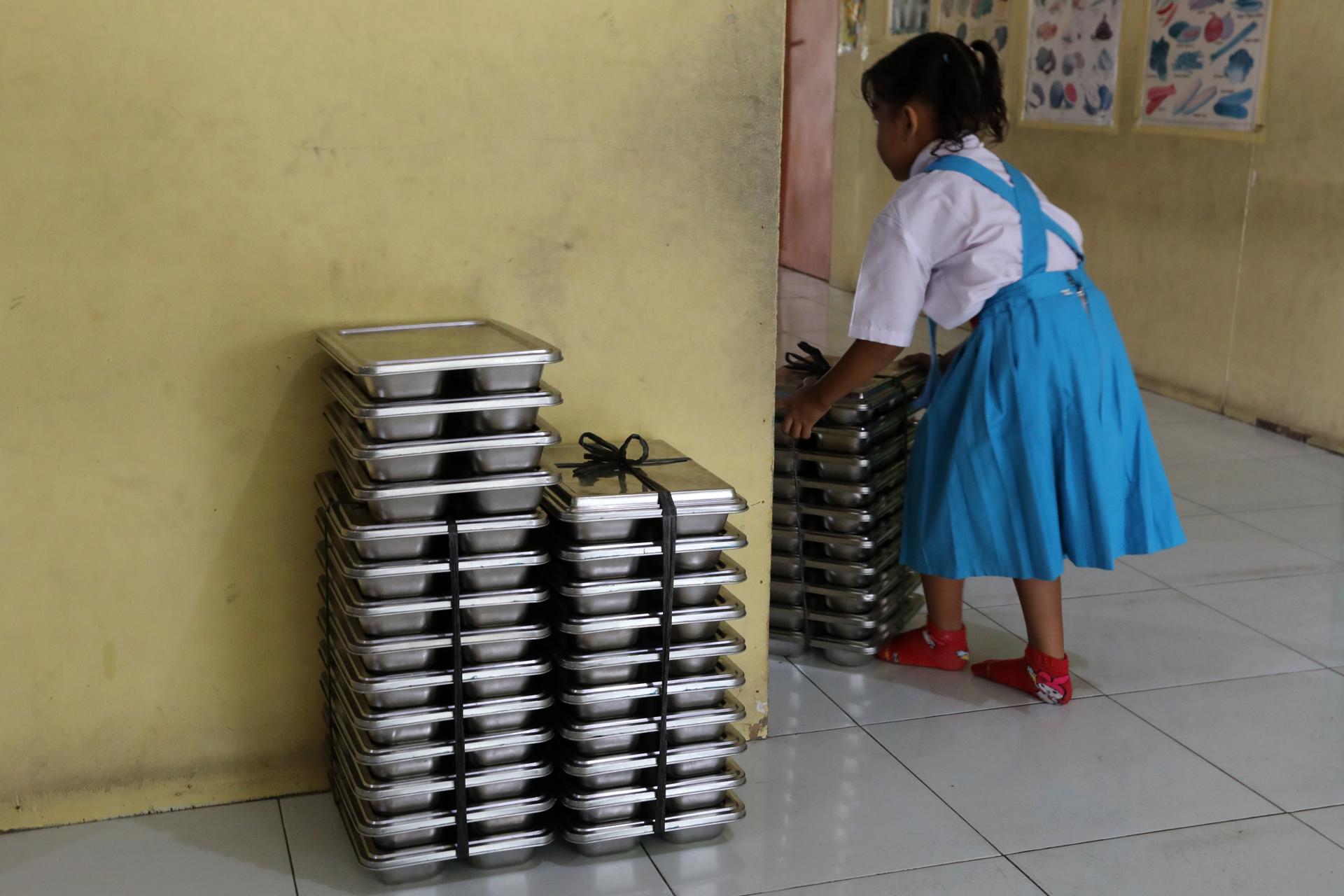 KEUTAPANG (Indonesia), 29/09/2025.- Un alumna apila bandejas de comida en una escuela de Keutapang, Aceh Besar, Indonesia, en el marco de un programa gubernamental de comida gratuita que deja cerca de 6.000 intoxicaciones alimentarias entre niños beneficiarios, según la Agencia Nacional de Nutrición. EFE/EPA/HOTLI SIMANJUNTAK
