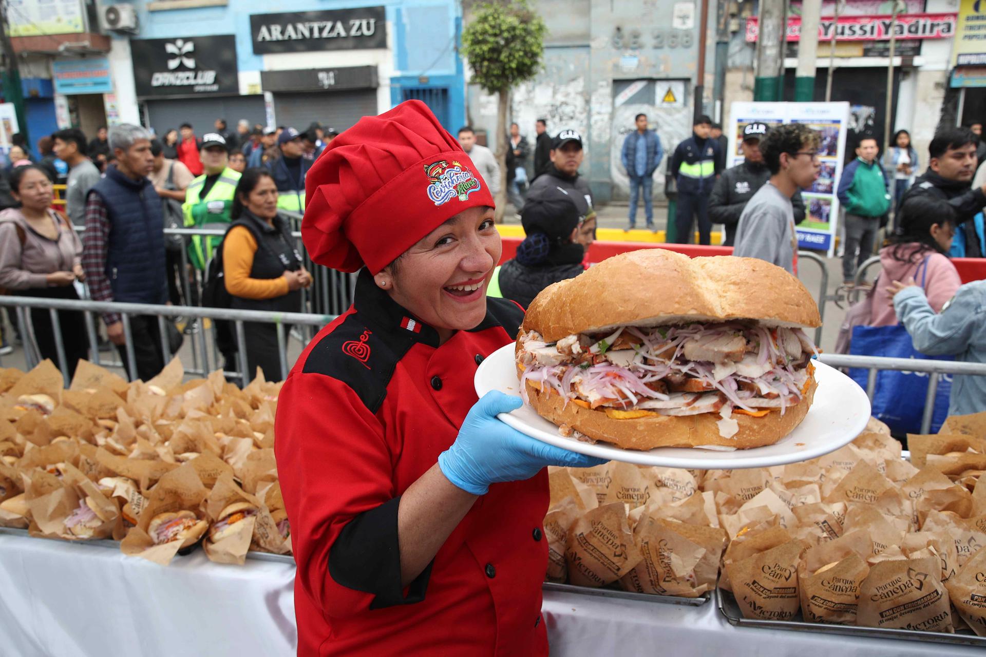 Una persona sostiene un pan con chicharrón este viernes, en Lima (Perú). EFE/ Paolo Aguilar

