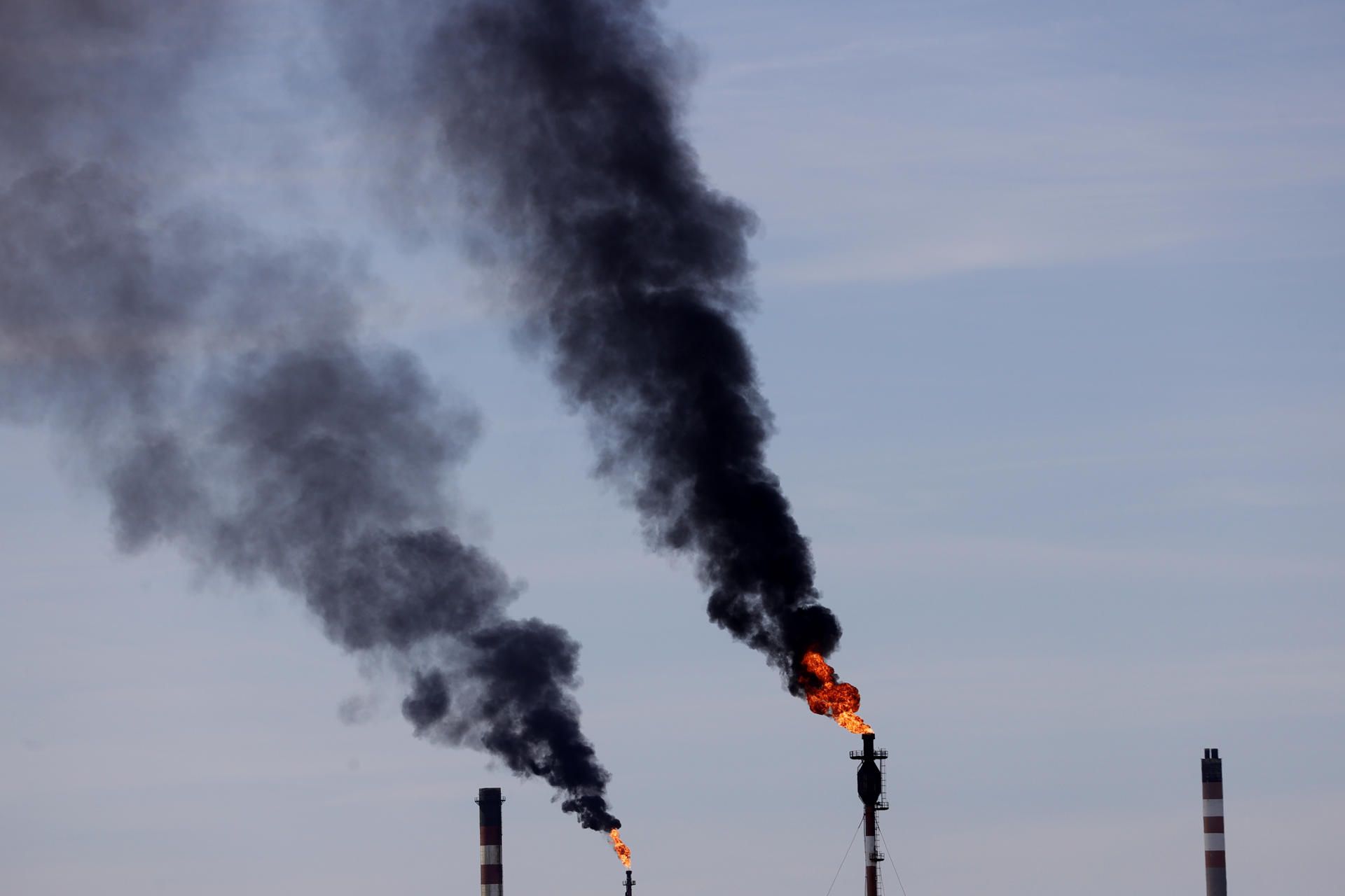 Imagen de archivo de dos chimeneas de una refinería. EFE/Cabalar