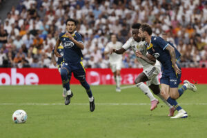 El delantero brasileño del Real Madrid Vinícius Jr (c) pelea por el balón con el jugador del RCD Espanyol Edu Expósito, durante el partido de la jornada 5 de LaLiga EA Sports, que disputaron el Real Madrid y el RCD Espanyol, en el estadio Santiago Bernabéu de la capital española. EFE/Sergio Pérez