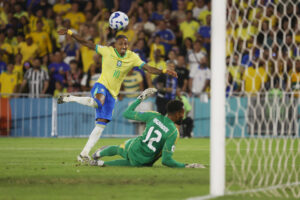 El delantero brasileño Raphinha (i) supera al guardameta chileno Lawrence Vigouroux en una maniobra del partido que la Canarinha ganó este jueves por 3-0 en el estadio Maracaná. EFE/ Antonio Lacerda