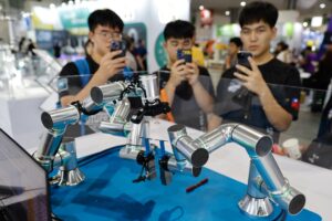 Varios jóvenes observan varios brazos robóticos durante la reciente Taiwan Automation Intelligence and Robot Show in Taipei, Taiwan. EFE/EPA/RITCHIE B. TONGO