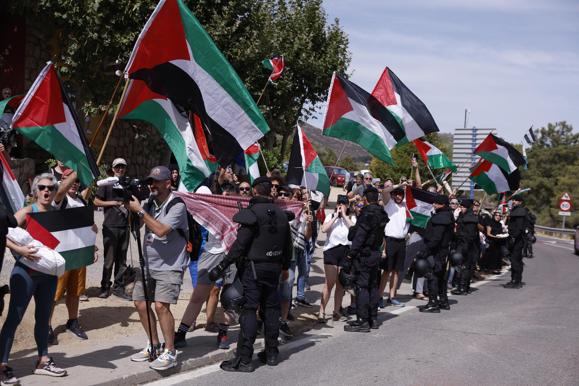 Manifestantes propalestinos antes de darse la salida de la vigésima etapa de La Vuelta a España disputada este sábado entre las localidades madrileñas de Robledo de Chabela y el Puerto de Navacerrada. EFE/ Javier Lizón