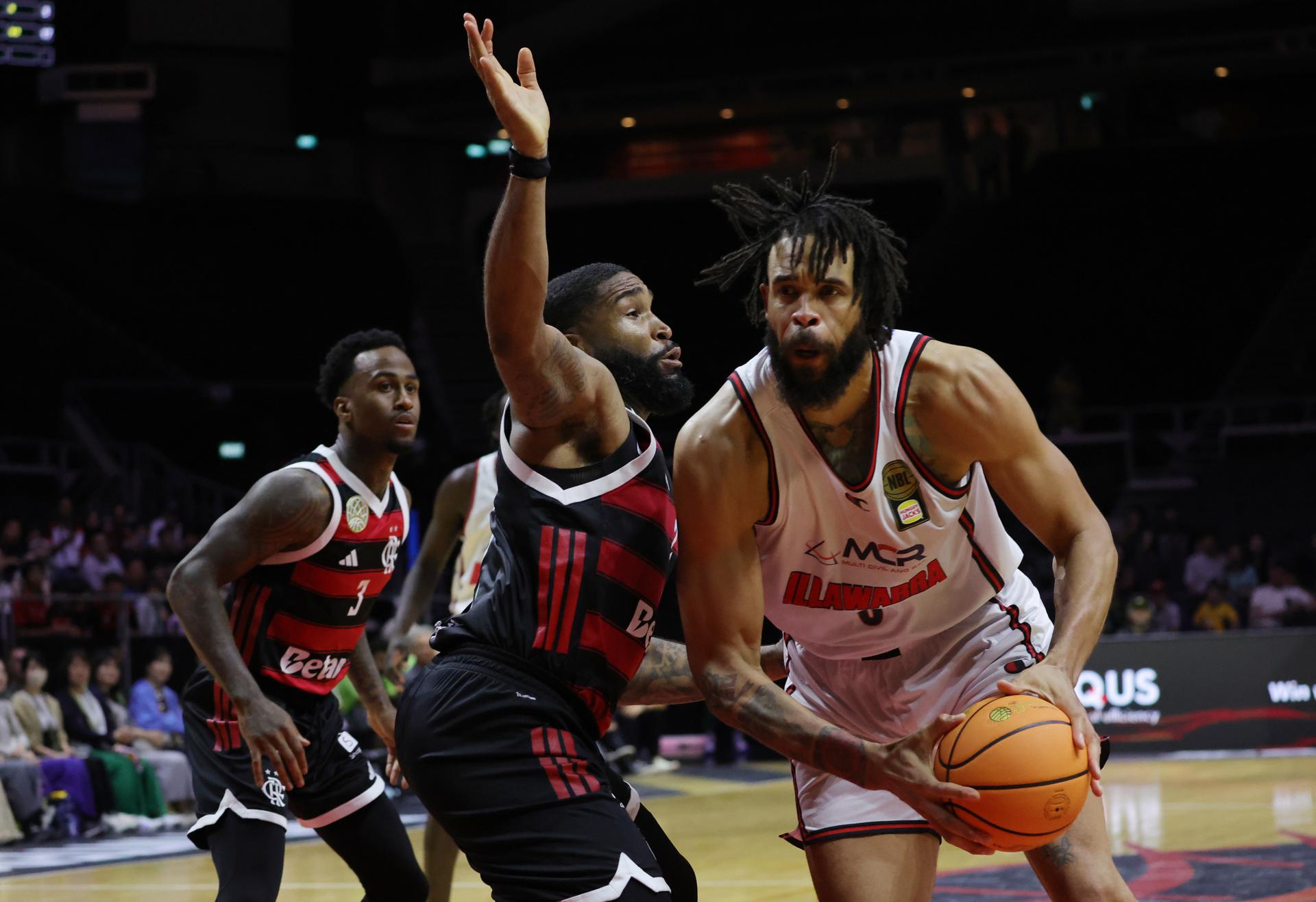 JaVale McGee (D), de Illawarra Hawks ,en acción contra Markeith Cummings (2-I), de Flamengo, durante el partido de baloncesto de la Copa Intercontinental FIBA 2025. EFE/EPA/HOW HWEE YOUNG
