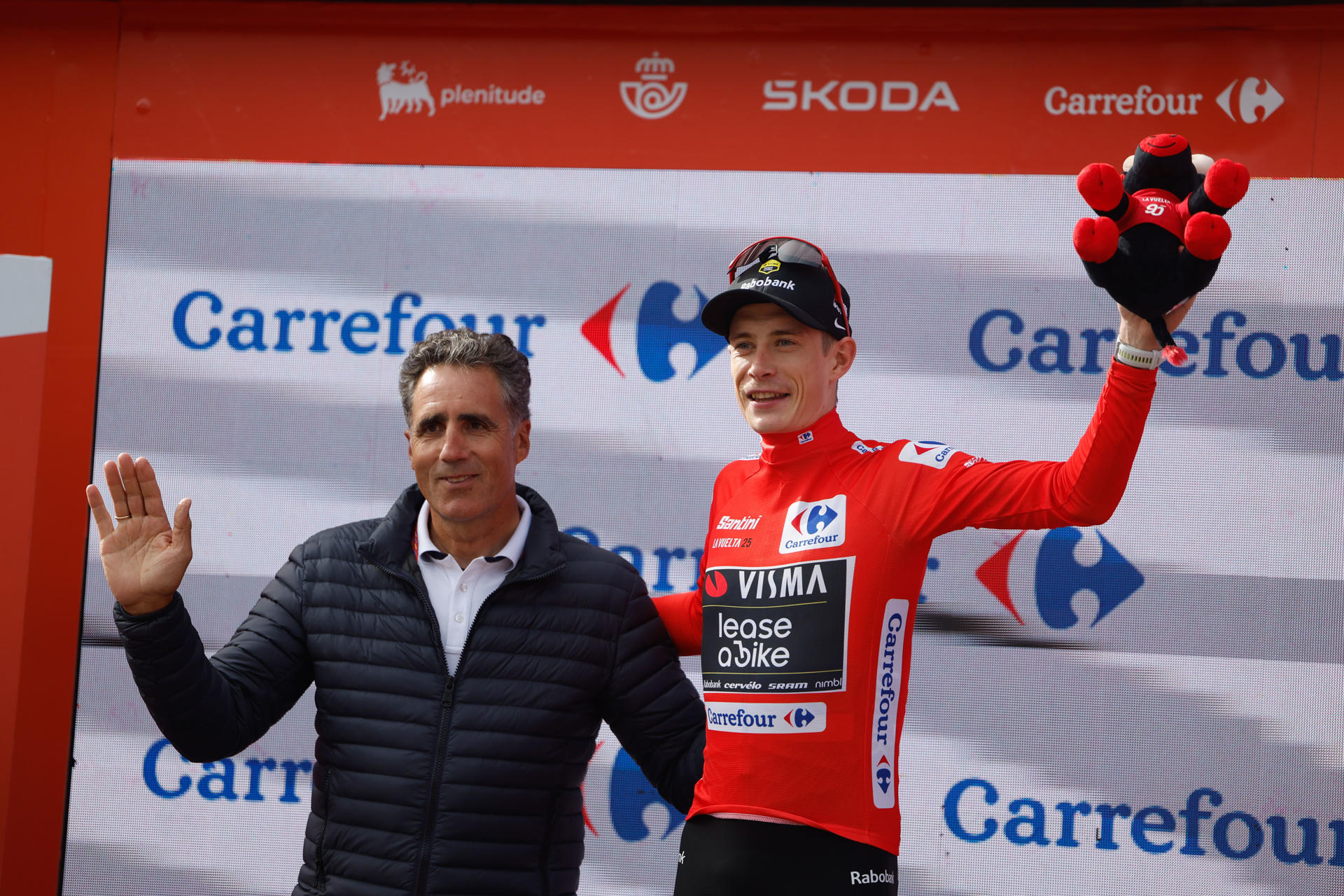 El danés Jonas Vingegaard (Visma), en el podio como líder de la Vuelta Ciclista a España tras la décima etapa, junto al exciclista Miguel Indurain (i), disputada este martes entre el Parque de la Naturaleza Sendaviva (Navarra) y final en el Ferial Larra Belagua. EFE/Javier Lizón
