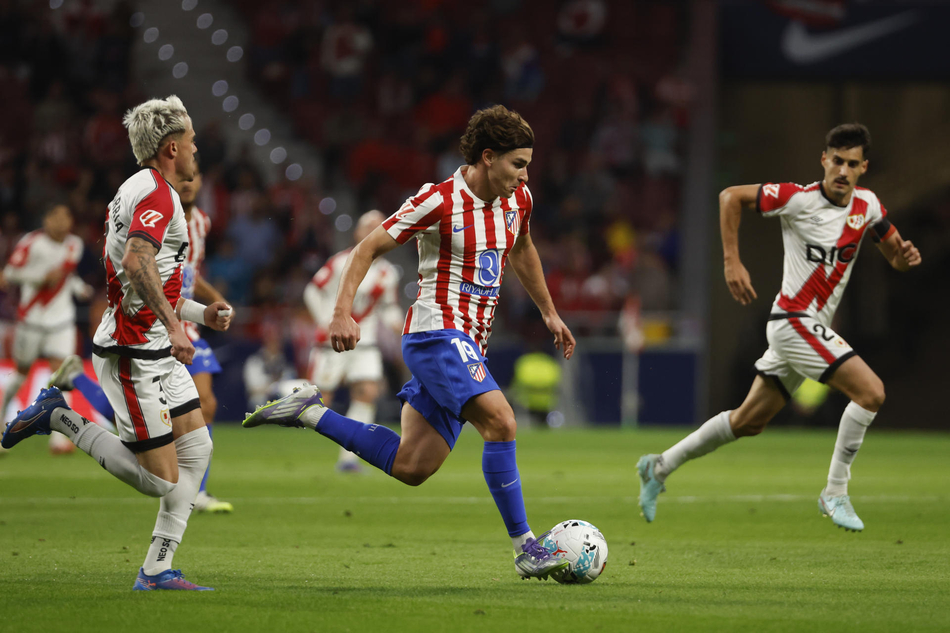 El delantero del Atlético de Madrid Julián Álvarez (c) controla el balón ante los defensas del Rayo Vallecano durante el partido de la jornada 6 de Liga que disputan en el estadio Riyadh Air Metropolitano, en Madrid. EFE/Juanjo Martín
