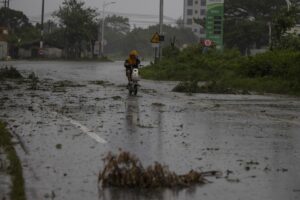 MAOMING (China), 24/09/2025.- Una persona conduce una scooter por una carretera cubierta de escombros en medio del paso del tifón Ragasa en Maoming, provincia de Guangdong, China. EFE/EPA/ANDRES MARTINEZ CASARES