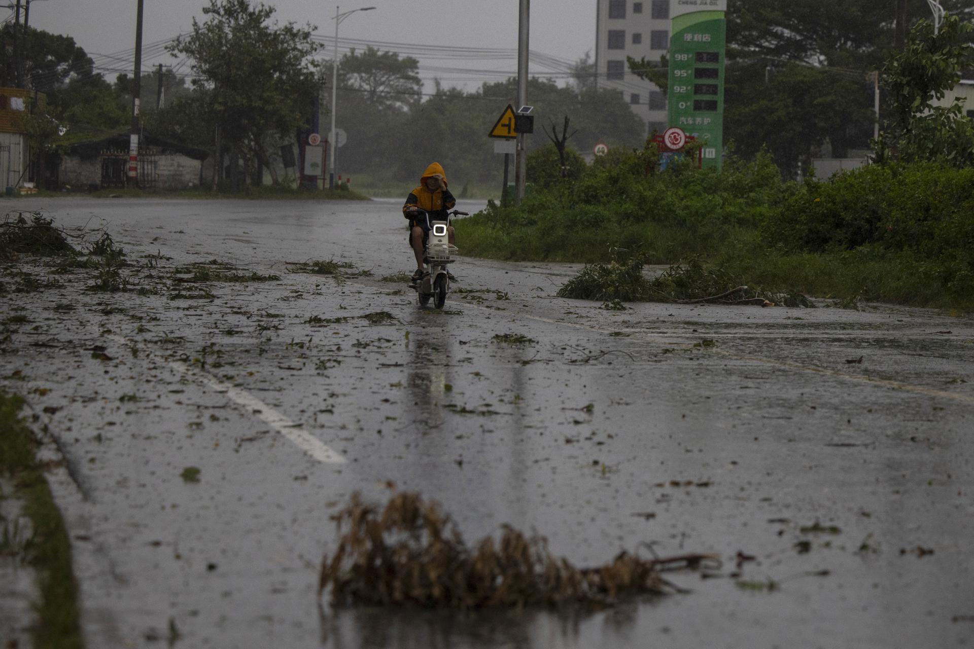 MAOMING (China), 24/09/2025.- Una persona conduce una scooter por una carretera cubierta de escombros en medio del paso del tifón Ragasa en Maoming, provincia de Guangdong, China. EFE/EPA/ANDRES MARTINEZ CASARES