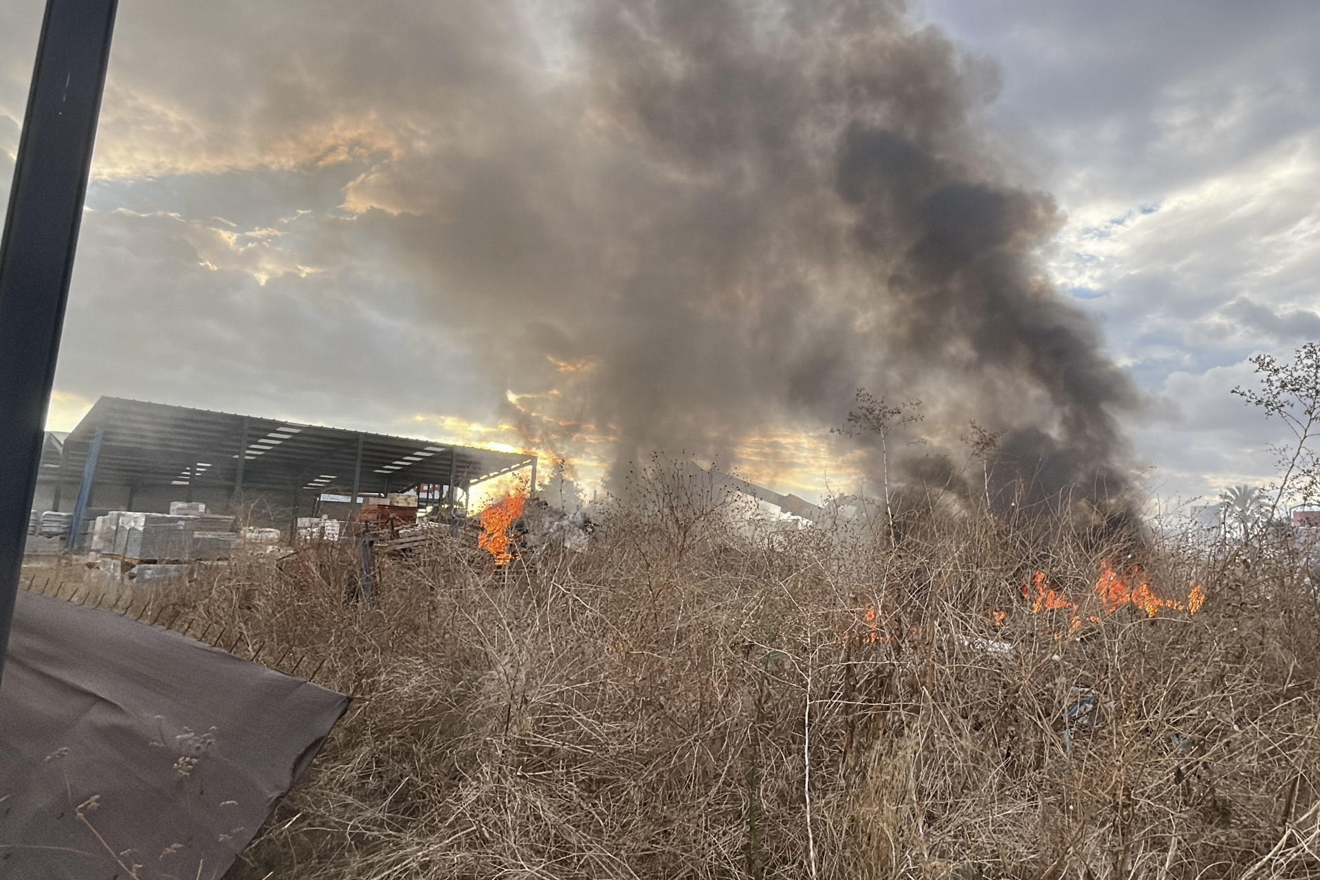 Un incendio afecta desde poco antes de las 19:00 horas de este lunes a un almacén de materiales de construcción en Palomares del Río (Sevilla), sin que haya personas afectadas, según ha informado el servicio Emergencias 112 Andalucía. EFE/Fermín Cabanillas
