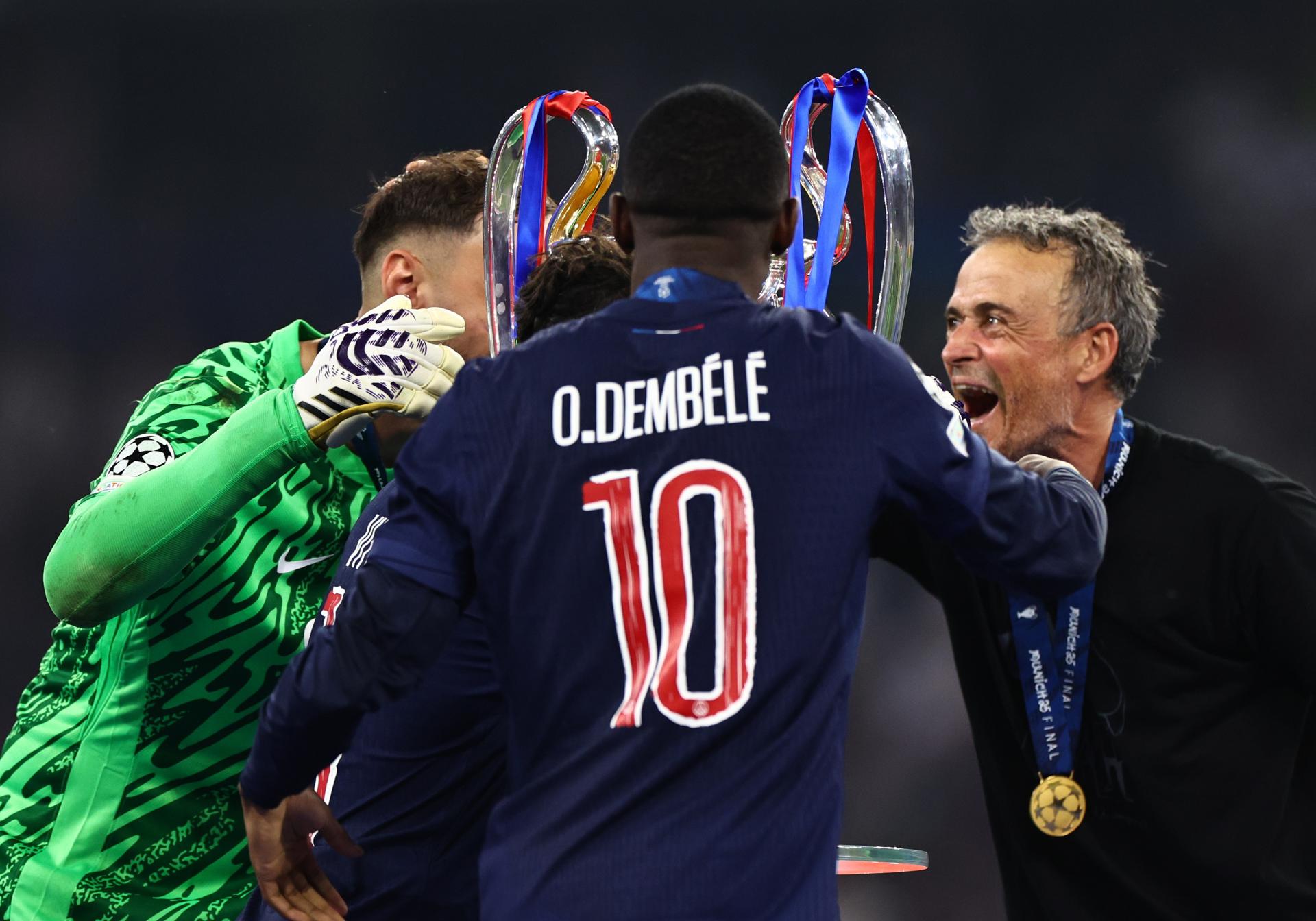 Fotografía de Anna Szilagyi, en la que puede verse en una imagen de archivo del 31 de mayo de 2025 al futbolista del PSG Ousmane Dembélé (centro), entre el portero Gianluigi Donnarumma (i) y el entrenador, Luis Enrique Martínez, tras ganar el título de Liga de Campeones frente al Inter de Milán. EFE
