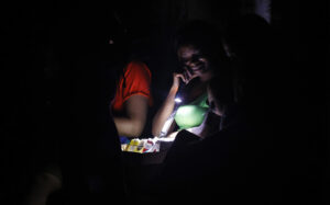 Una mujer ilumina con una linterna cigarros para venderlos durante un apagón este 10 de septiembre de 2025, en La Habana (Cuba). EFE/Ernesto Mastrascusa