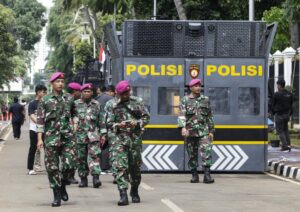 JAKARTA (Indonesia), 02/09/2025.- Indonesian Marine members walk past an anti riot police vehicle as they prepare for possible protests in Jakarta, Indonesia, 02 September 2025. Protests erupted across the country following the death of a motorbike hailing driver during an earlier protest against the housing allowance for members of parliament on the night of 28 August 2025. (Protestas) EFE/EPA/BAGUS INDAHONO