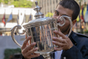 El tenista español Carlos Alcaraz, besa el trofeo que lo acredita como campeón del Abierto de Estados Unidos 2025 este lunes, en el Rockefeller Center de Nueva York. EFE/Ángel Colmenares