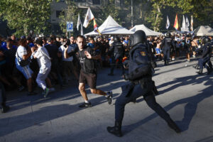Agentes de la Policía Nacional se enfrentan a aficionados del Olympique de Marsella a su llegada al estadio Santiago Bernabéu antes del partido de la primera jornada de la Liga de Campeones entre Real Madrid y Olympique de Marsella, este martes en Madrid. EFE/ Rodrigo Jiménez