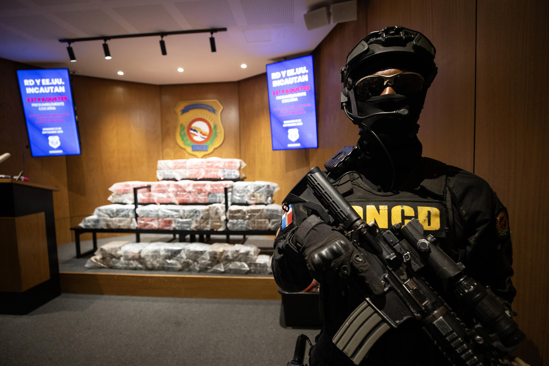 Un integrante de la Dirección Nacional de Control de Drogas (DNCD) de República Dominicana fue captado este domingo, 21 de septiembre, al custodiar 377 paquetes de la presunta cocaína que iba a bordo de la más reciente embarcación bombardeada por el Ejército los Estados Unidos en aguas del mar Caribe, en Santo Domingo (República Dominicana). EFE/Orlando Barría