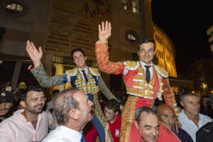 Los toreros Andrés Roca Rey y Paco Ureña (d) salen a hombros por la puerta grande, tras cortar dos orejas cada uno en el tercer festejo de la Feria Taurina de Murcia celebrado este martes en la plaza de toros de La Condomina. EFE/Marcial Guillén