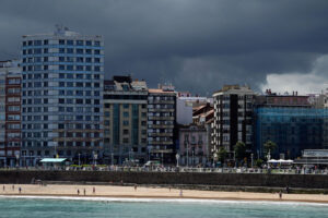 Vista de la playa de San Lorenzo con nubes oscuras de tormenta al fondo, en julio pasado. EFE/Paco Paredes