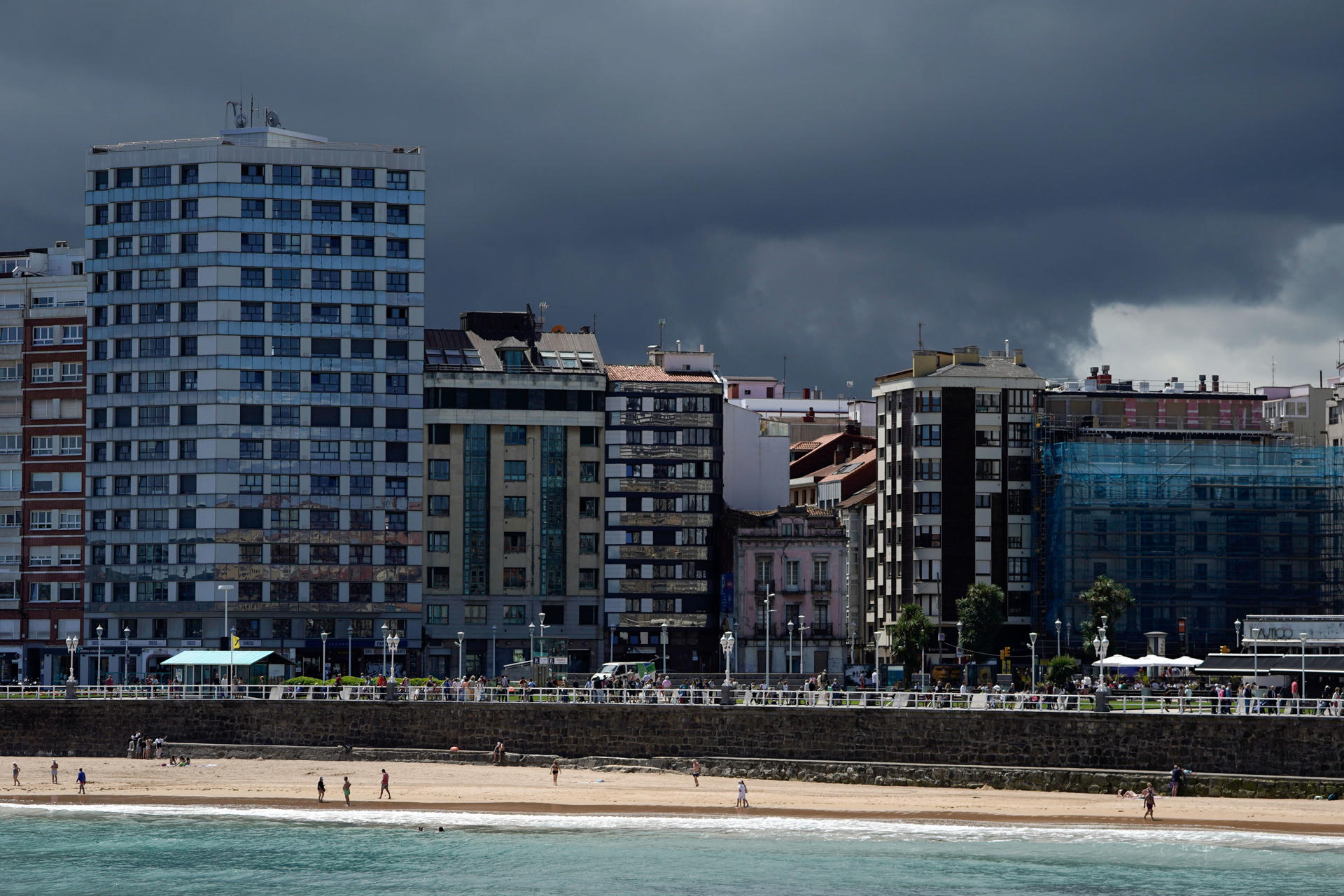 Vista de la playa de San Lorenzo con nubes oscuras de tormenta al fondo, en julio pasado. EFE/Paco Paredes